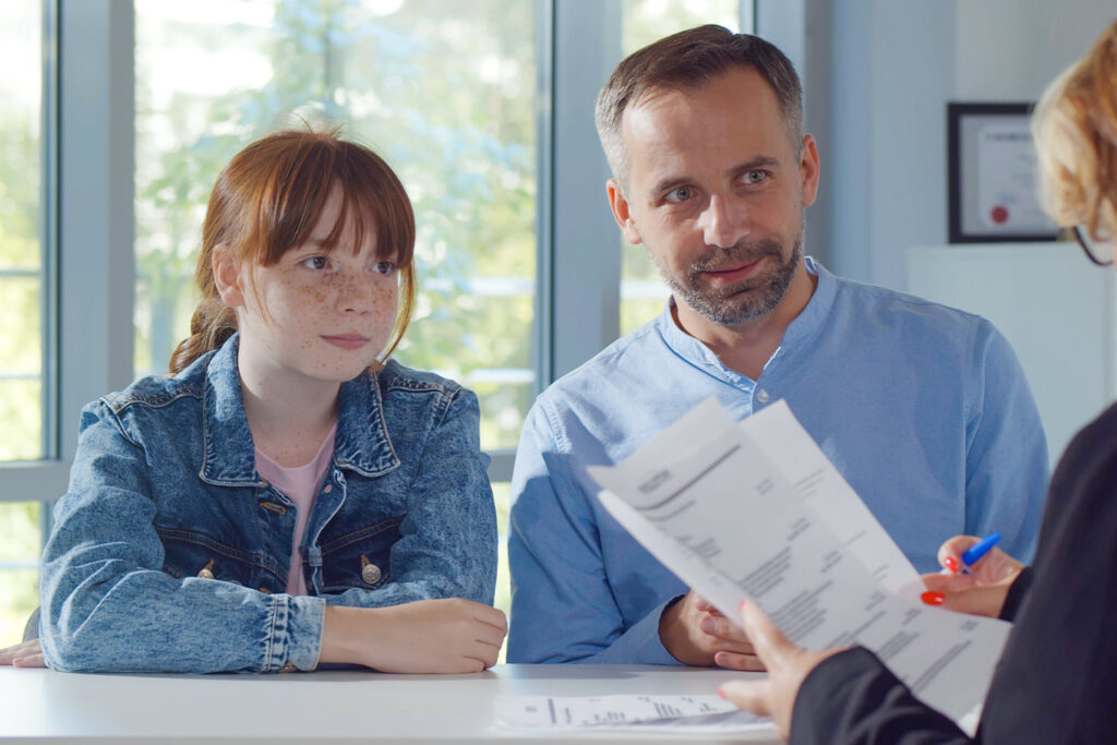 father and daughter talking to lawyer
